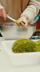 Close up of reparing moss for a glass terrarium at home workshop with plants in the background. Home gardening, greenery business concept