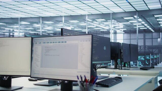 Code running on computer screens in empty data center workspace, used for troubleshooting rackmounts. Close up of script working on desktop PC monitors upgrading mainframes systems in server room