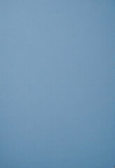 A plain blue background with a subtle texture, resembling a soft, muted blue paper or fabric