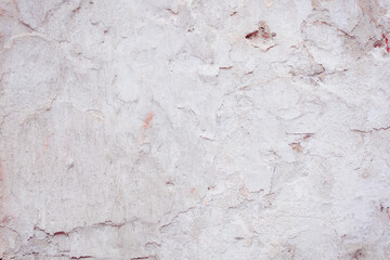 White concrete wall with natural defects. Fragment of the cement surface with natural texture. Monochrome palette of shades.