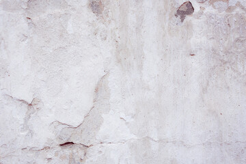 White concrete wall with natural defects. Fragment of the cement surface with natural texture. Monochrome palette of shades.