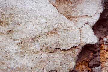 White concrete wall with natural defects. Fragment of the cement surface with natural texture. Monochrome palette of shades.