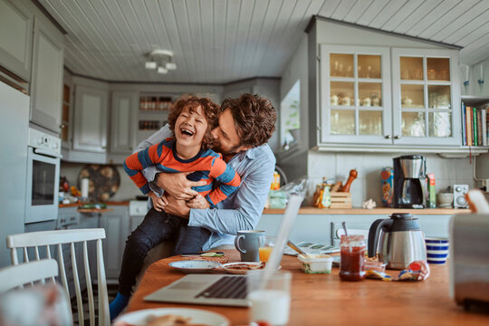 Father and son having fun at kitchen table