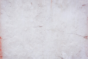 White concrete wall with natural defects. Fragment of the cement surface with natural texture. Monochrome palette of shades.