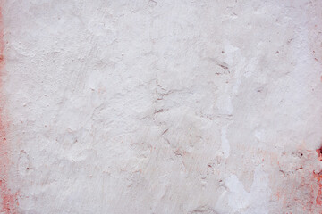 White concrete wall with natural defects. Fragment of the cement surface with natural texture. Monochrome palette of shades.