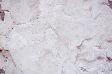 White concrete wall with natural defects. Fragment of the cement surface with natural texture. Monochrome palette of shades.