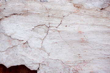 White concrete wall with natural defects. Fragment of the cement surface with natural texture. Monochrome palette of shades.