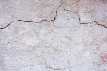 Grey peeling wall with natural defects. Fragment of the concrete shabby surface with natural texture. Red white palette of shades.