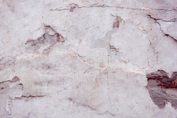 Fototapeta premium Grey peeling wall with natural defects. Fragment of the concrete shabby surface with natural texture. Red white palette of shades.
