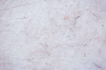 Grey peeling wall with natural defects. Fragment of the concrete shabby surface with natural texture. Red white palette of shades.