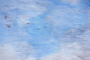 Blue peeling wall with natural defects. Fragment of the concrete shabby surface with natural texture. Blue white palette of shades.