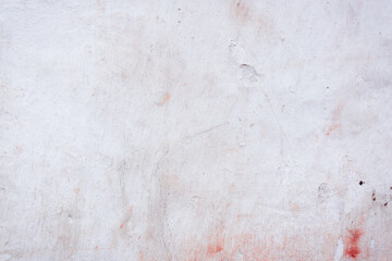 Grey peeling wall with natural defects. Fragment of the concrete shabby surface with natural texture. Red white palette of shades.