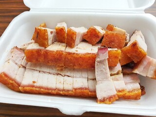 Chinese crispy roast pork. Chinese roast pork with crispy skin, sliced in takeout packet
