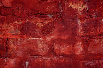 A fragment of a red brick wall with pronounced texture. Natural age defects in the form of cracks and abrasions. Rough surface with traces of dried paint.
