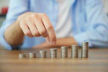 young man hands counting coins on a table for save money