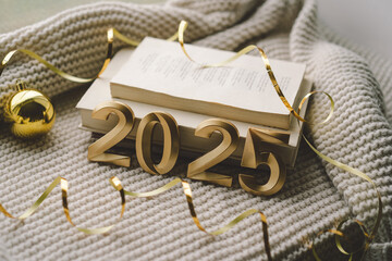 Golden numerals reading 2025 are surrounded by festive decorations, including stars and ornaments,...