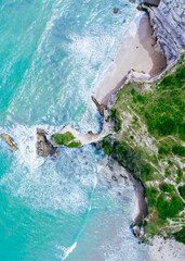 Azure clear water hits the rocky coast of coral beach. Aerial top view © Balnyes Visuals