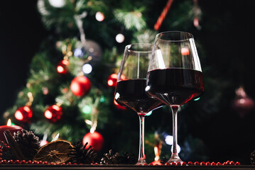 Glasses of wine on the background of a decorated Christmas tree. New Year