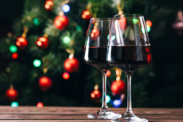 Glasses of wine on the background of a decorated Christmas tree. New year mood