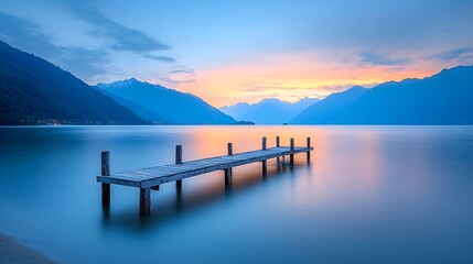 Obraz premium Experience serenity by the tranquil lakeside dock at dawn with majestic mountains in the background