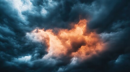 Obraz premium Dramatic storm clouds illuminated by orange light, creating a stunning contrast against dark blue skies.
