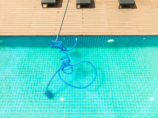 Pool maintenance with scoop net  and automatic robot cleaner.