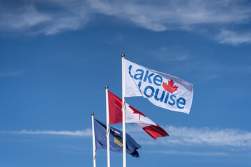 Lake Louise, Canada and Alberta flags flying in the sky