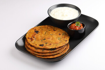   Indian flat bread Methi paratha or Methi thepla is a Indian breakfast dish served with curd and tomato chutney or dip 