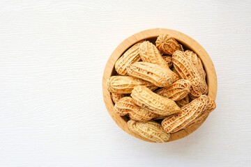 Boiled Peanuts in wooden bowl on white background	, top view