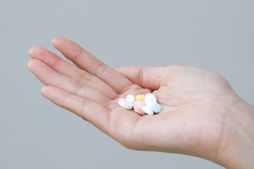 close up hand man taking multiple colors pills in hand. Stop drug use Taking Medication health care medical concept