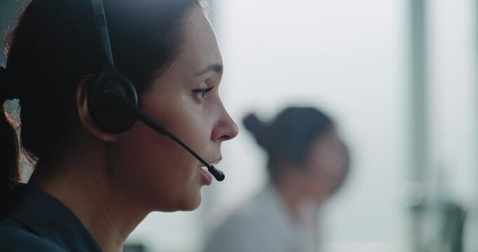 Close up of Caucasian female hotline operator in headset having conversation on call with customer, providing online assistance for client. Technical support specialist working in call center office.