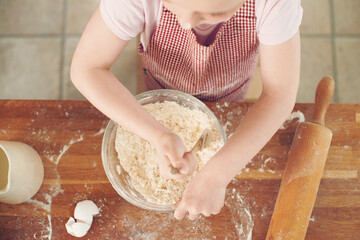 Baking, mix and above of child in kitchen with dough for learning to bake cake, dessert and pastry. Bowl, culinary skills and young girl with ingredients, recipe and food for sweet treats in home