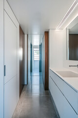 Bright and modern hallway with sleek cabinetry and polished concrete floors in a contemporary home