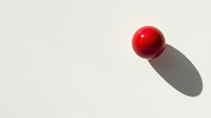 Glossy red rubber ball floating against a white background with shadow effects