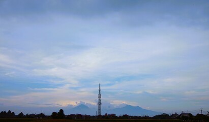 photo of sky view in the afternoon with view of houses, towers and mountains