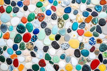  Colorful pebbles and stones arranged in an abstract mosaic pattern on a white background