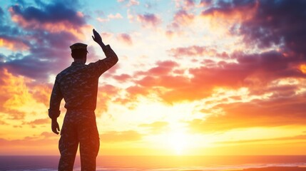 A soldier saluting against a vibrant sunset backdrop.