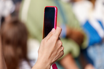 A person is holding a pink cell phone and taking a picture