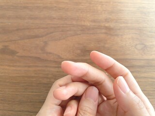 机の上で指先を触る女性の手元