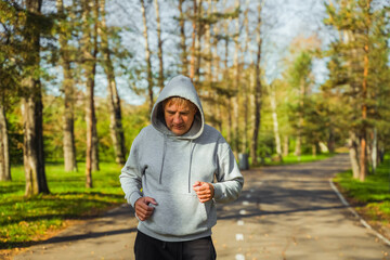 Portrait of an elderly man running in a public park