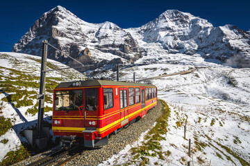 Electric tourist cogwheel train on the snowy slope in Switzerland