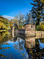 Wasserburg Wellbrunnen mit Spiegelungen im Wasser bei klarem Sonnenschein. Außentürme und Mauern