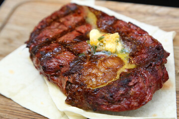 Medium rare steak placed on pita bread on a special wooden board. Beef steak on a wooden board.