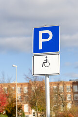 A blue parking sign indicating designated parking for people with disabilities. The sign has a wheelchair icon on a white background