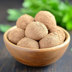 A bowl of homemade chocolate truffles dusted with cocoa powder.