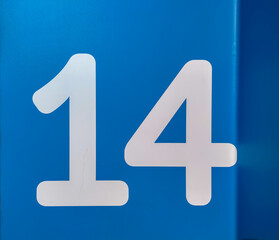 number fourteen, 14 in number on a blue surface with a dark side