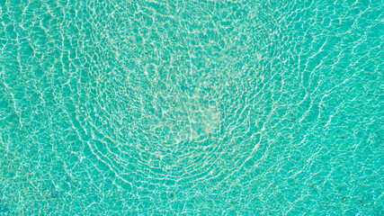 Aerial view of clear turquoise water with sunlight reflecting off the surface