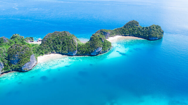 Aerial view of scattered islands with blue ocean water at Wayag Island, Raja Ampat, West Papua, Indonesia. summer background and summer holiday concept. - Powered by Adobe