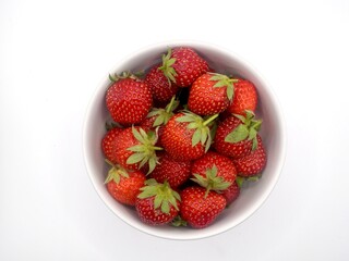 Top view of sweet strawberries on the white bowl isolated on a white background
