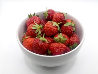 Close up image of sweet strawberries on the white bowl isolated on a white background